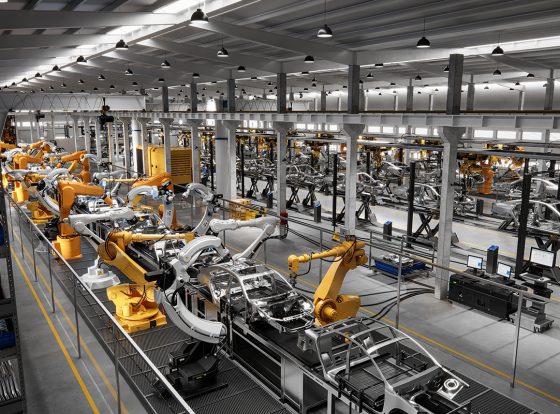 High Angle View Of Cars On Production Line In Factory. Many Robottic Arms Doing Welding On Car Metal Body In Manufacturing Plant. Image In 3D Render.